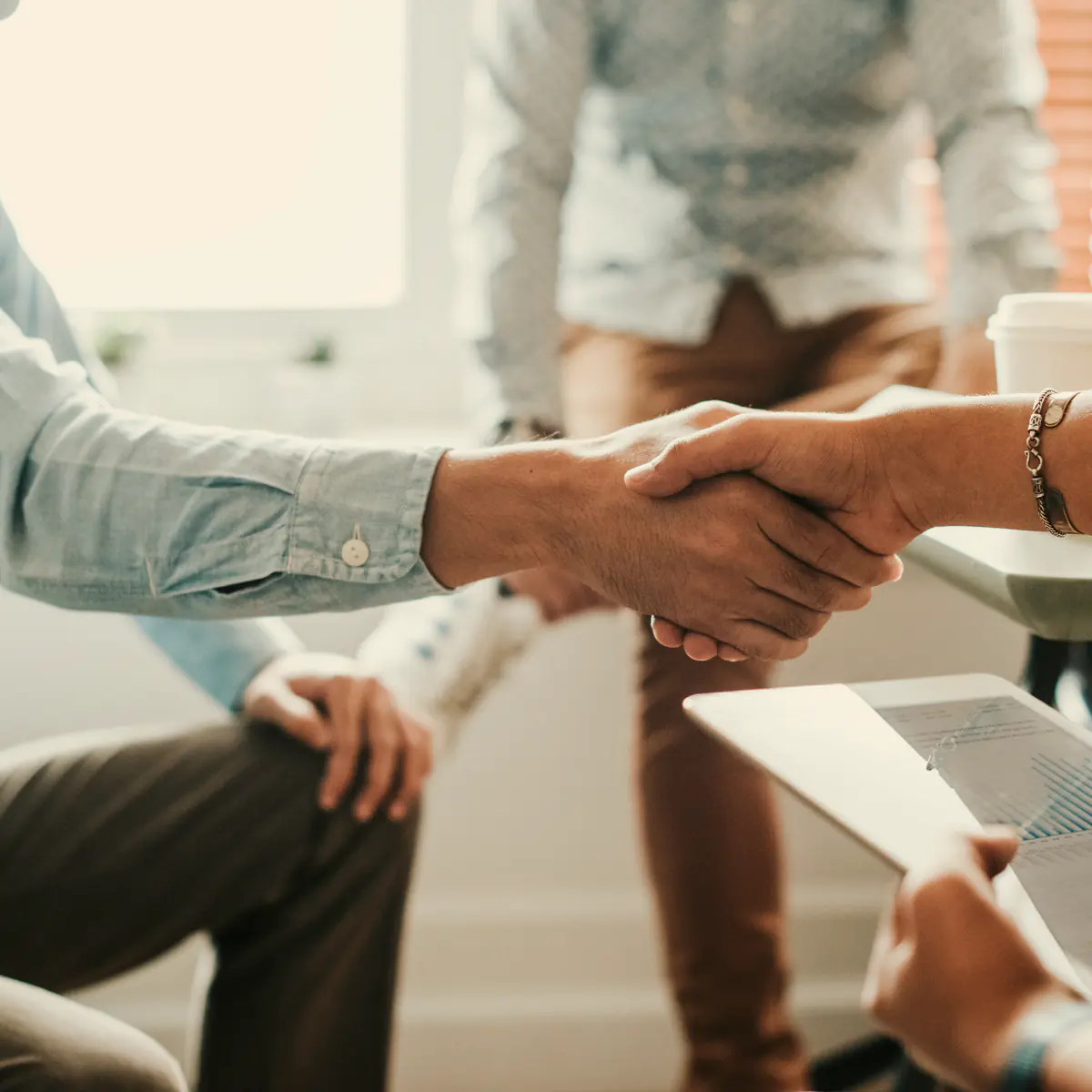 A salesperson shaking hands with a client after a meeting
