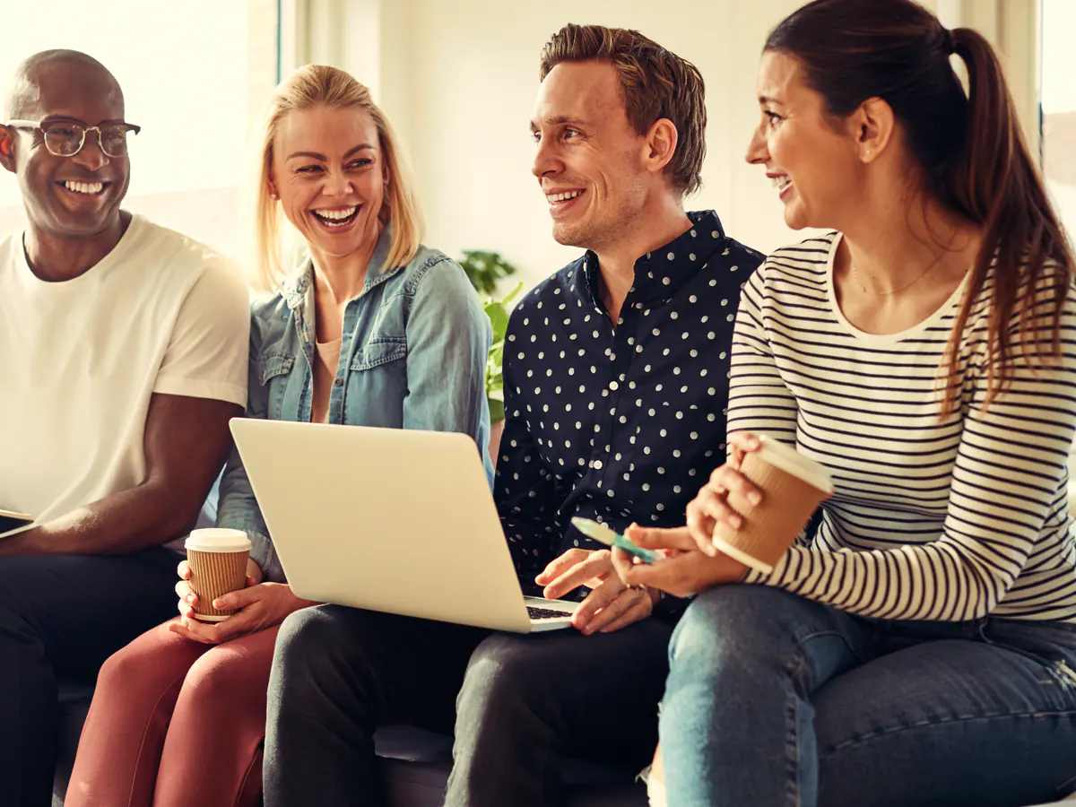 A software team talking through ideas around a laptop